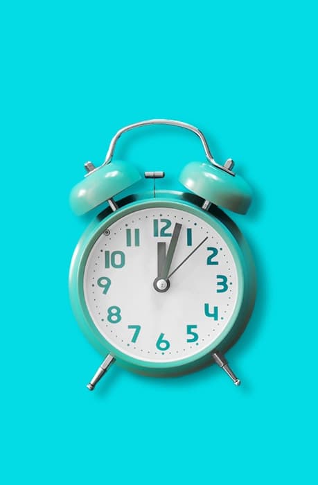 A blue alarm clock on a blue background