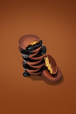 A pile of chocolate peanut butter cups, with some drizzles of chocolate syrup