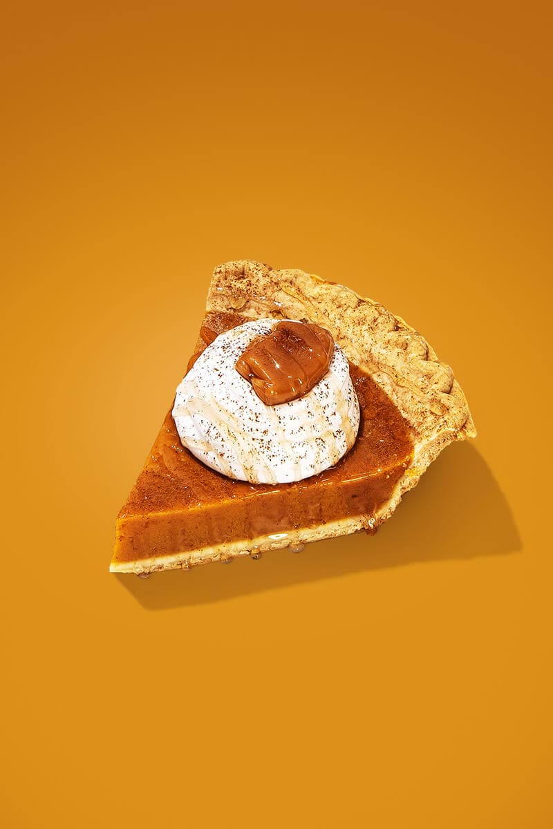 A slice of pumpkin pie, with a dollop of whipped cream
